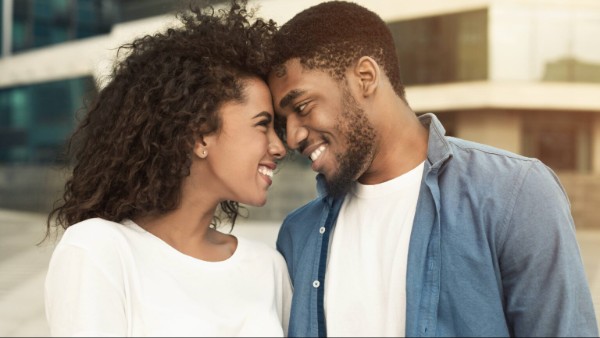 Tender couple touching foreheads, bonding to each other, walking in city
